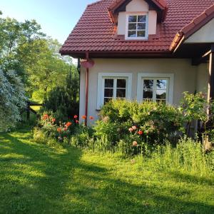a small house with flowers in the yard at Apartament Urocze miejsce in Kazimierz Dolny