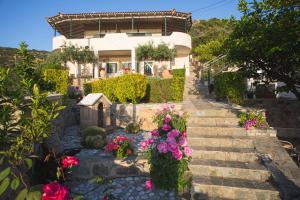 a house with stairs and flowers in front of it at Palataki in Kardamyli