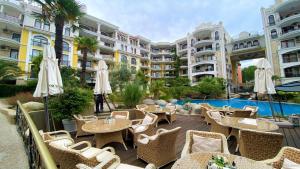 an outdoor patio with tables and umbrellas in a resort at Bratanov Harmony Monte Carlo in Sunny Beach