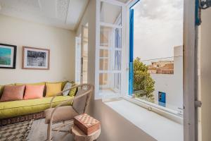 a living room with a green couch and a window at Dar Said in Essaouira