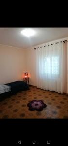 - une chambre avec un lit et une fenêtre avec un tapis dans l'établissement Santi Palace Hotel, à Gravina di Catania