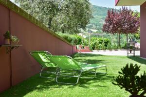 una silla verde en el césped en B&B Villa Passero, en Torricella Sicura