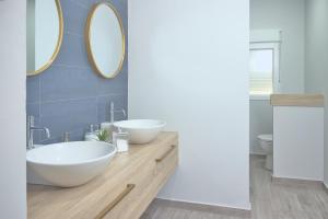 a bathroom with two sinks and two mirrors at Apartamento Circo Romano- con vistas al Circo Petfriendly in Merida +31 photos