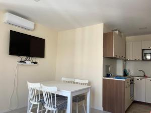 a small kitchen with a white table and chairs at Apartments Pomorie Tundzha 9 in Pomorie