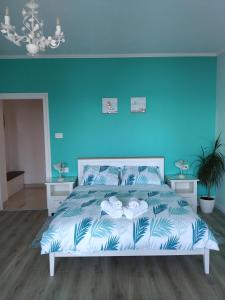 1 dormitorio con 1 cama con pared azul en Apartment Villa Edmea 2 en Rijeka