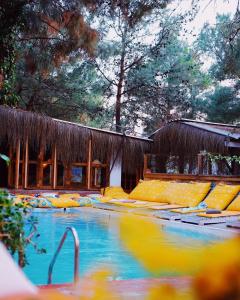 - une piscine avec des chaises jaunes devant un bâtiment dans l'établissement Kayserkaya Cottages, à Selçuk