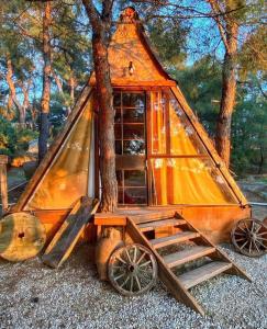 une petite cabane avec un arbre et un wagon en bois dans l'établissement Kayserkaya Cottages, à Selçuk