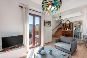een woonkamer met een tv en een bank en een tafel bij ApteraMare Tradidtional house 'New listing 2022' in Chania
