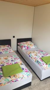 two beds sitting next to each other in a room at Domki przy Sosnowej in Ostrowo