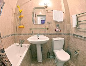 a bathroom with a sink and a toilet and a tub at Minzifa Inn in Bukhara