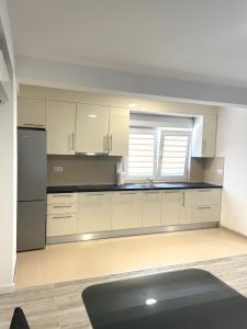 an empty kitchen with white cabinets and a refrigerator at Apartman Jure in Široki Brijeg