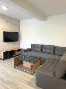 a living room with a couch and a flat screen tv at Apartman Jure in Široki Brijeg