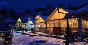 un edificio con nieve por la noche en Camping Cajupi, en Gjirokastra