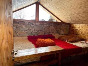 Cama en habitación con pared de piedra en Camping Cajupi, en Gjirokastra