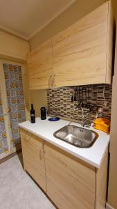 a kitchen with a sink and wooden cabinets at Casa Vacanze La Melagrana in Modica +30 photos