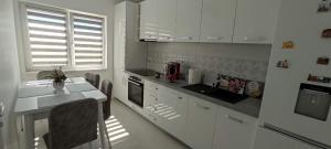 eine Küche mit weißen Schränken und einer Arbeitsplatte in der Unterkunft Julia's Residence in Cisnădie