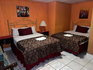 a hotel room with two beds and a lamp at Hotel Maya Copan Guamilito in San Pedro Sula