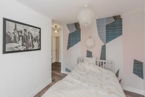 l'authentique en hyper centre ville في بوفيه: غرفة نوم مع سرير وملصق على الحائط