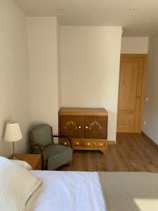 um quarto com uma cama, uma cadeira e uma cómoda em La Portella em Pauls de Flamisells