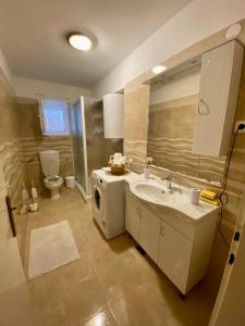 a bathroom with a sink and a washing machine at Apartment Darija with private pool in Kaštela