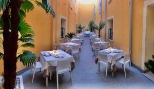 ランペドゥーザにあるAlba D'Amore Hotel & Spaの白いテーブルと椅子、ヤシの木があるレストラン