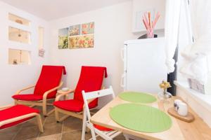 kuchnia z czerwonymi krzesłami, stołem i lodówką w obiekcie Apartman studio Sanja Klimno w mieście Klimno