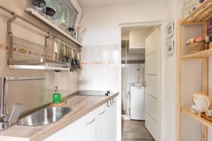 kuchnia z białymi szafkami i zlewem w obiekcie Apartman studio Sanja Klimno w mieście Klimno