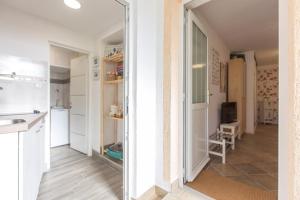 een keuken met witte kasten en een grote spiegel bij Apartman studio Sanja Klimno in Klimno