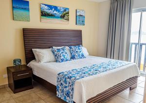 una camera da letto con un letto grande con cuscini blu di Palapa Beach Resort Curacao a Jan Thiel