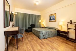 贝洛奥里藏特Dayrell Hotel e Centro de Convenções的配有床和书桌的酒店房间