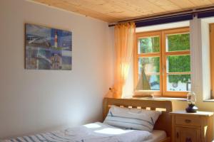 Schlafzimmer mit einem Bett und einem Fenster in der Unterkunft Holstein-Höfle, ArgenInsel in Argenbühl