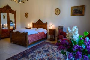 - une chambre avec un lit, un miroir et des fleurs dans l'établissement Domaine de Lardoisière, à Château-Salins