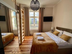 a bedroom with two beds and a large window at Agapella Apartamenty- Foksal Sopot Rooms in Sopot