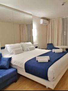 um quarto com uma cama grande e 2 cadeiras azuis em BEST HOUSE ORBI CITY em Batumi