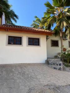 une maison blanche avec un palmier en face dans l'établissement Beautiful Loft! Walk from the beach!, à Tamarindo