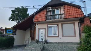 una pequeña casa con techo rojo en Apartmani Odmor i Mir en Vranje