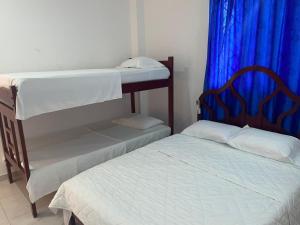 1 dormitorio con 2 literas y cortina azul en Habitacion Playa Linda 102, en Coveñas