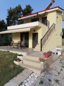 a house with a staircase and a patio at EPavli Xenia Pefkochori-Paliouri 30m in Paliouri