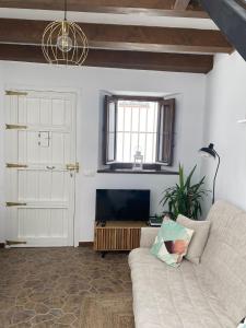 a living room with a white couch and a window at Casa Arequipa in Vejer de la Frontera