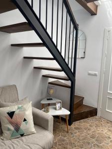 a living room with a staircase and a couch at Casa Arequipa in Vejer de la Frontera