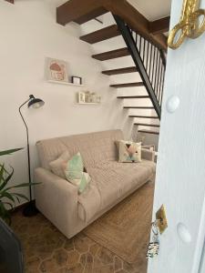a living room with a couch and a staircase at Casa Arequipa in Vejer de la Frontera