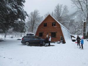 a group of people standing outside of a barn in the snow at 4 Coihues de Sollipulli in Rumiñano