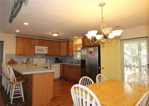 eine Küche mit einem Tisch und einem schwarzen Kühlschrank in der Unterkunft Watercolors in Edisto Island