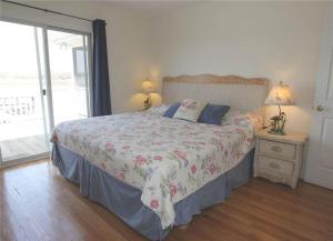1 Schlafzimmer mit einem Bett mit Blumenbettdecke und einem Fenster in der Unterkunft Watercolors in Edisto Island