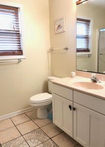 ein Badezimmer mit Toilette, Waschbecken und Spiegel in der Unterkunft Watercolors in Edisto Island