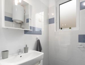 biała łazienka z umywalką i lustrem w obiekcie Bora Apartment Pula w Puli +11 zdjęć