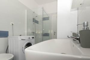 biała łazienka z pralką i umywalką w obiekcie Bora Apartment Pula w Puli