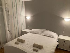 a bedroom with a white bed with two towels on it at Apartmani Lovre i Zara in Zadar