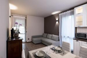 L'Olivo nel Chianti في Quercegrossa: مطبخ وغرفة معيشة مع أريكة وطاولة