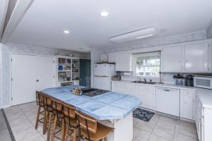 a kitchen with white cabinets and a blue counter top at Escape in Edisto Island